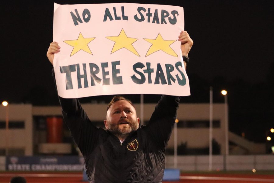 Head Coach Nick Chetta holds signs that says, No All Stars, Three Stars, signifying their success despite having no All-Stars on the team.