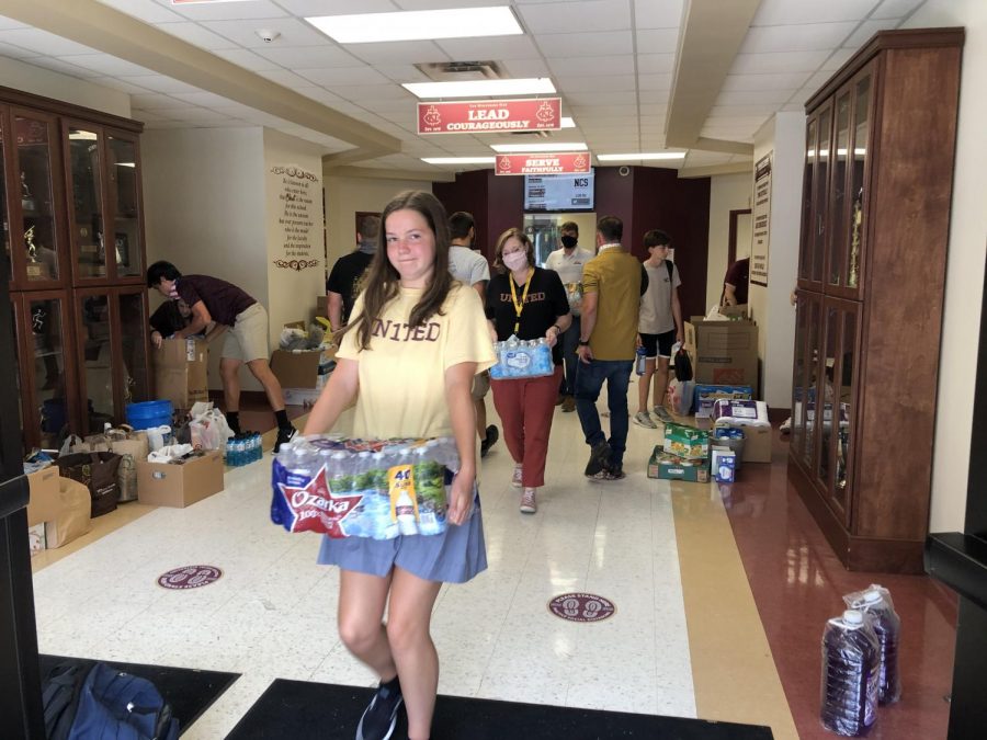 Katelyn James, along with other students and faculty, is pictured here helping carry items to the trailer.
